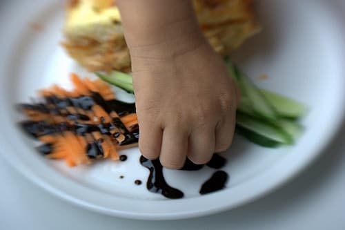 A hand reaching out to fix the presentation of a plate