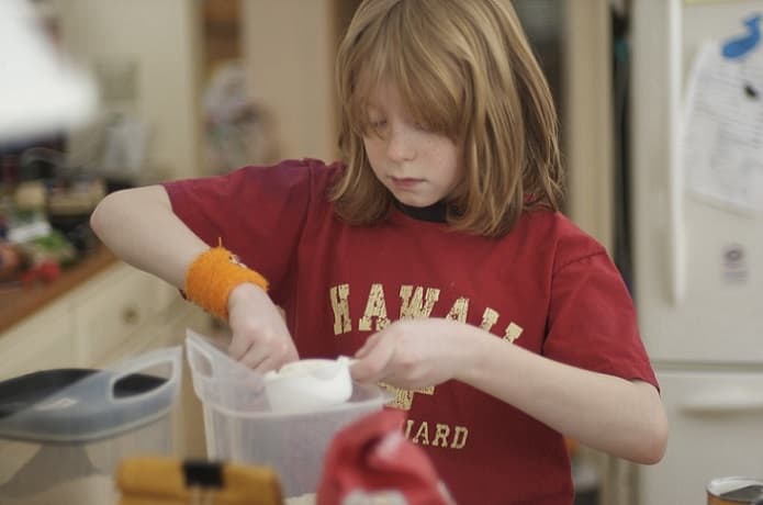 A boy scooping flour