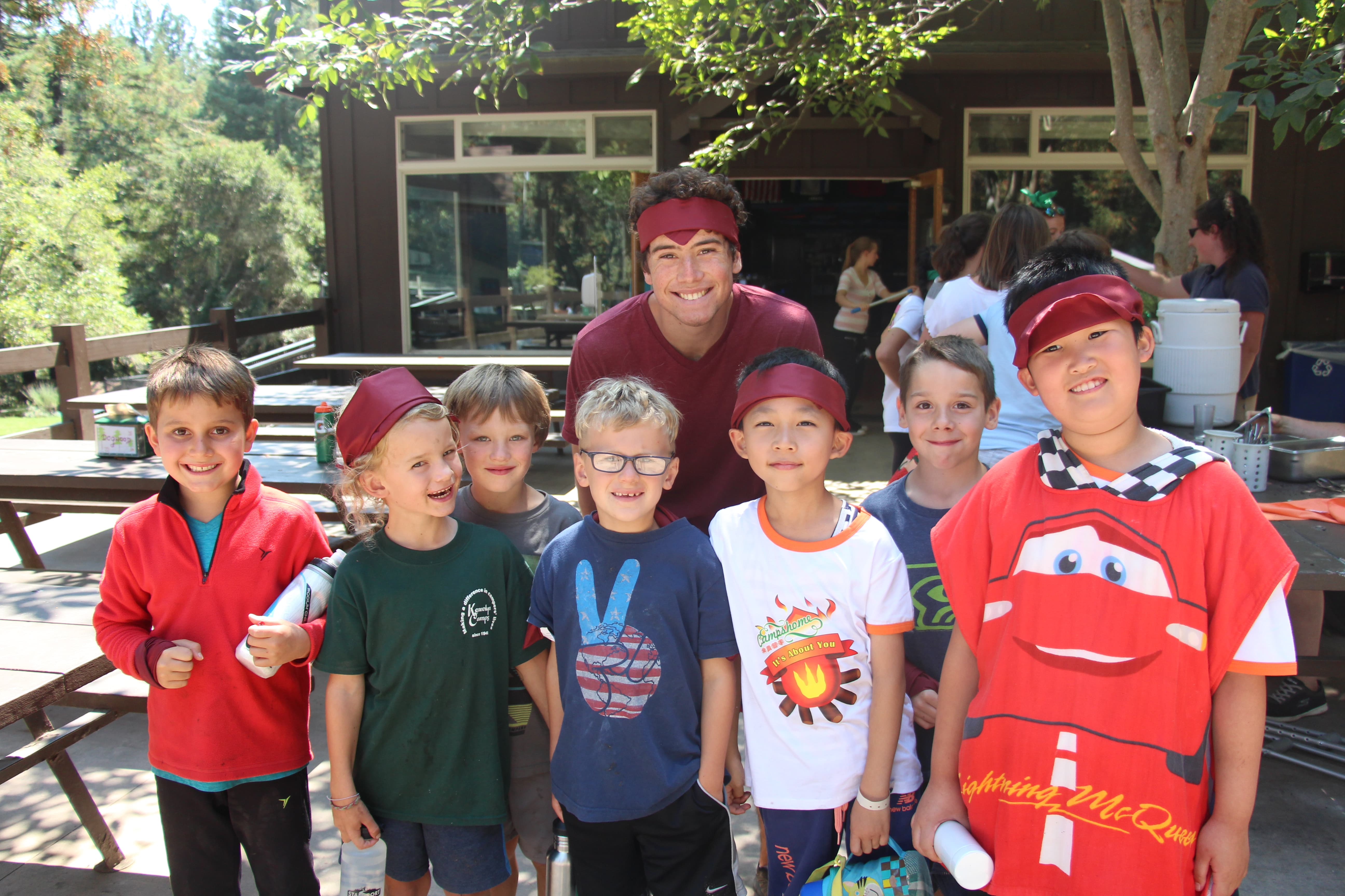 A counselor with a group of campers wearing maroon bandanas