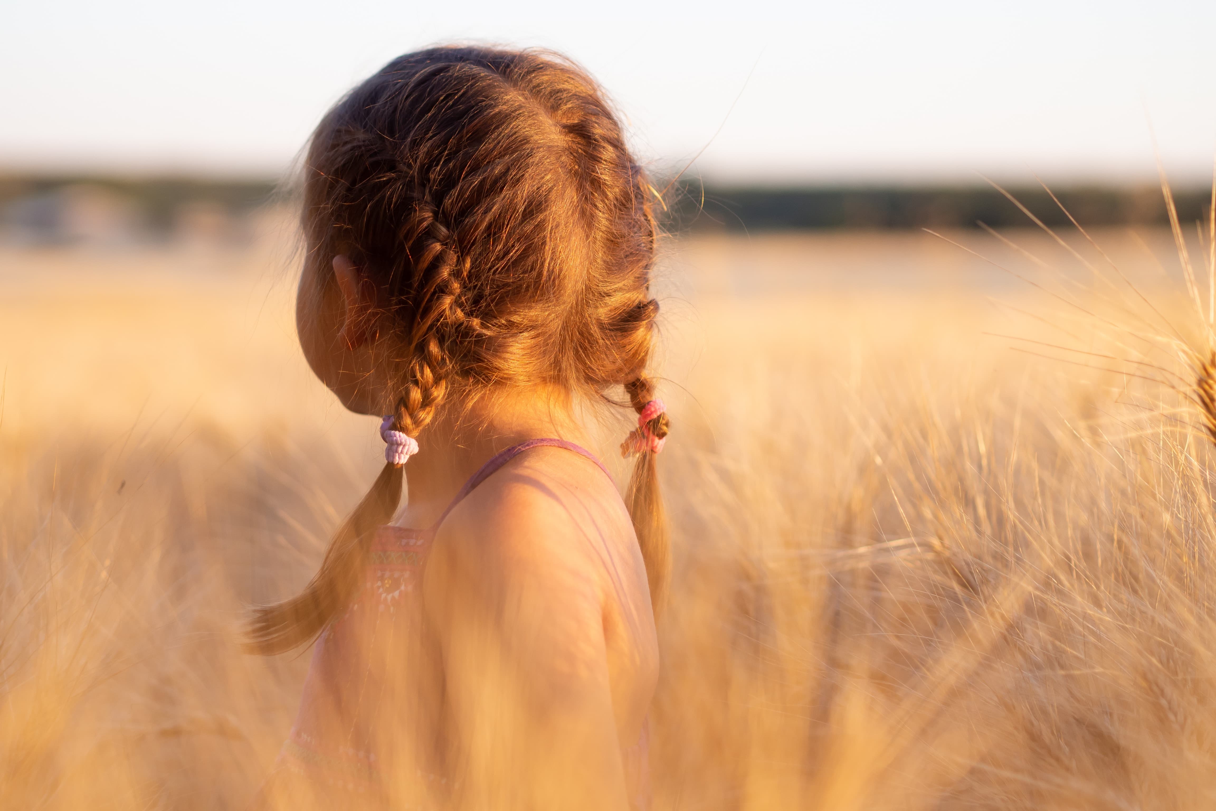 A girl in a field looking for something 