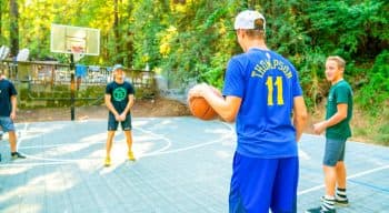 Boys play basketball at summer camp