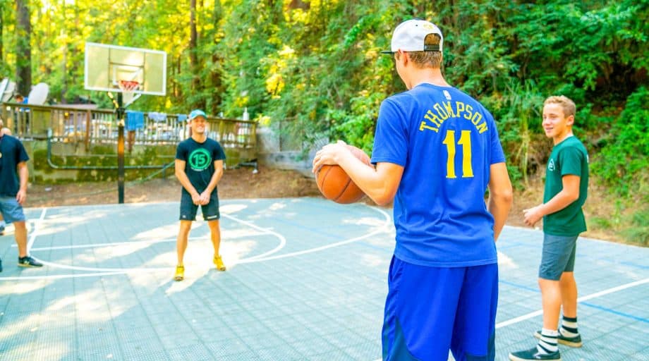 Boys play basketball at summer camp