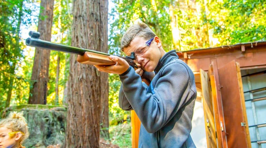 Camper aims rifle at targets