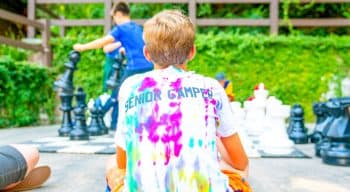 Camper sits near giant chess board