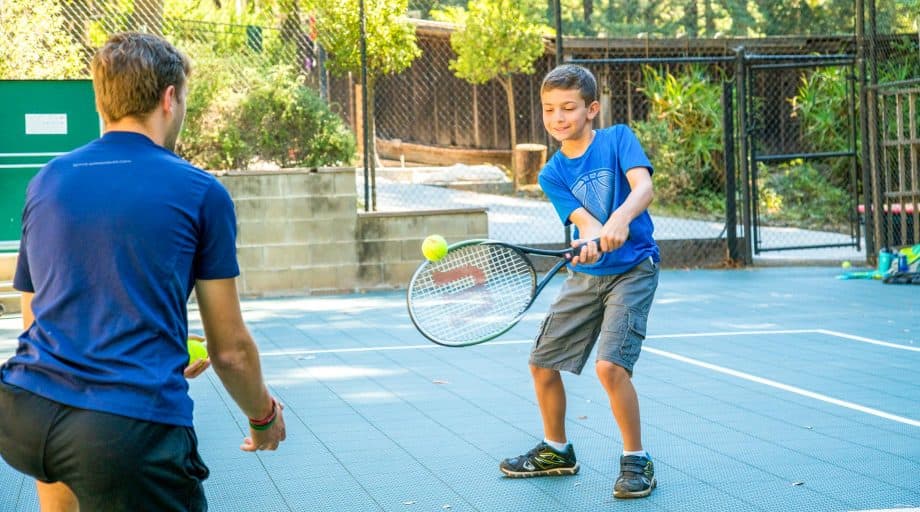 Summer camper practices tennis swing