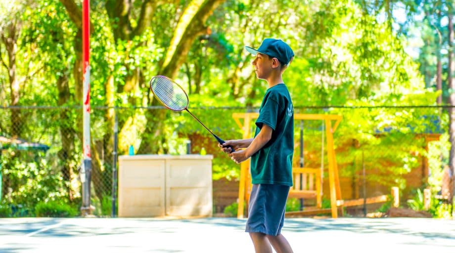 Camper holds tennis racquet