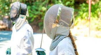 Campers stand in fencing gear