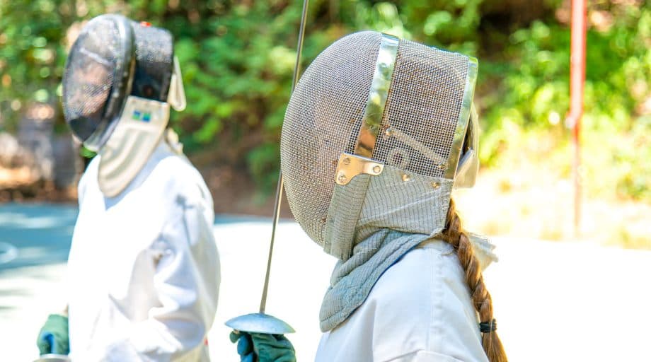 Campers stand in fencing gear