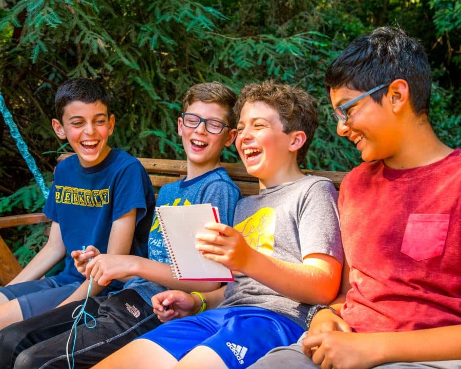 Boys sitting on bench laugh together