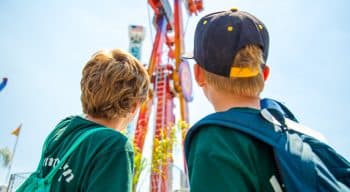 Two campers looking at a large amusement park ride