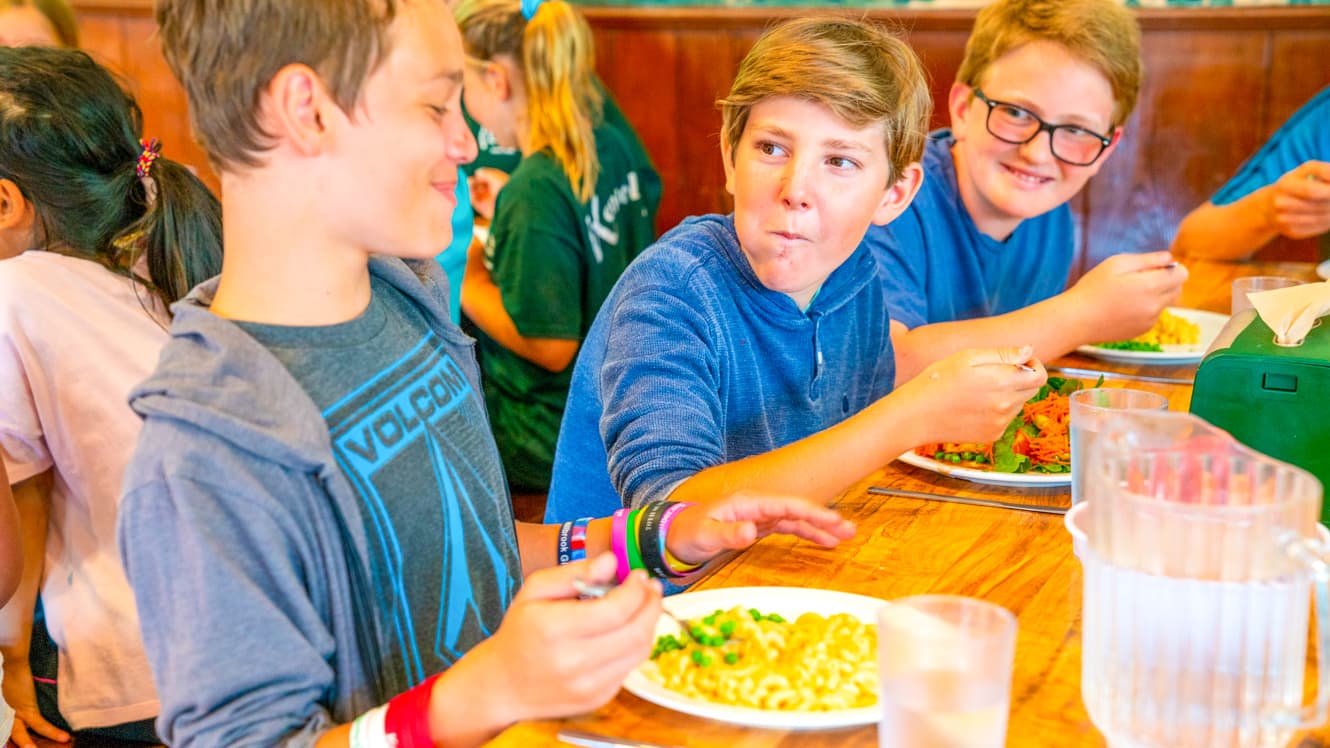 Boys eat lunch at summer camp