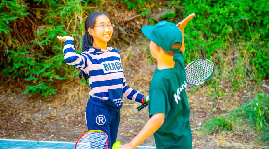 Campers high five on tennis court