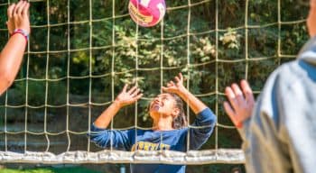 Girl prepares to hit volleyball at summer camp