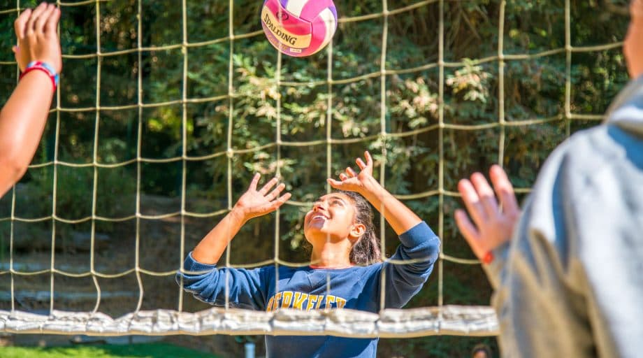 Girl prepares to hit volleyball at summer camp