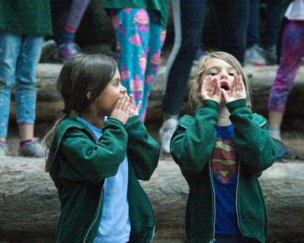 Two young girls yelling at the camp fire