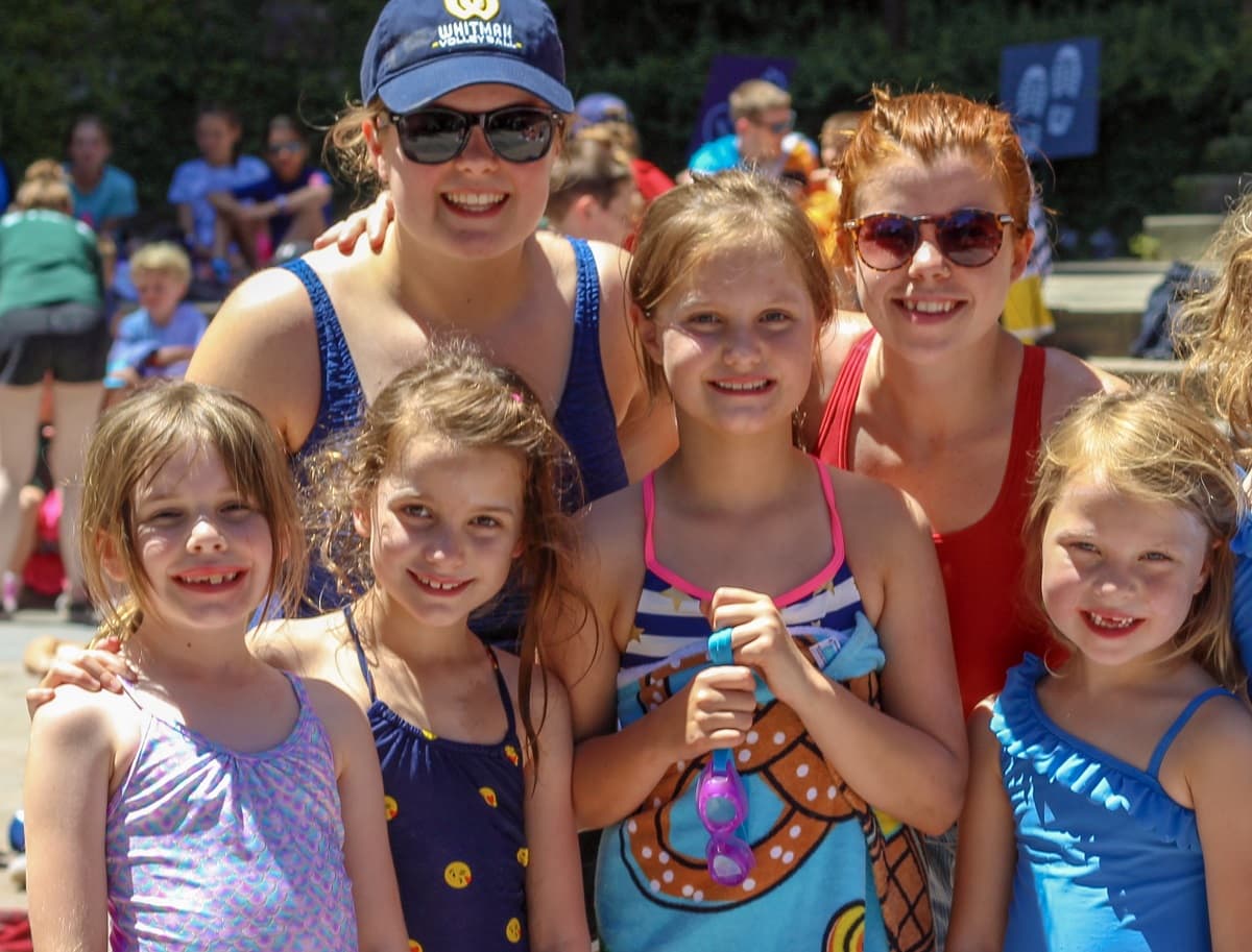 Counselors with campers smiling at the pool