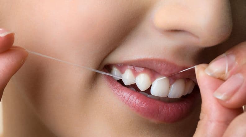 A woman flossing her teeth