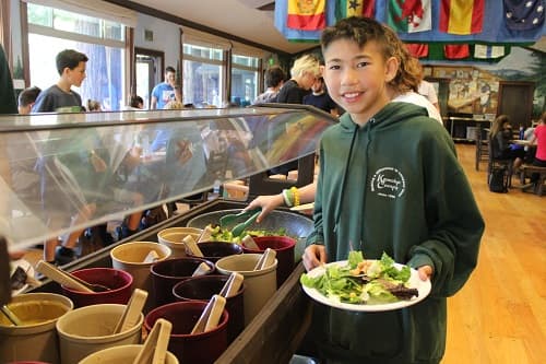 A boy making a salad at the buffet