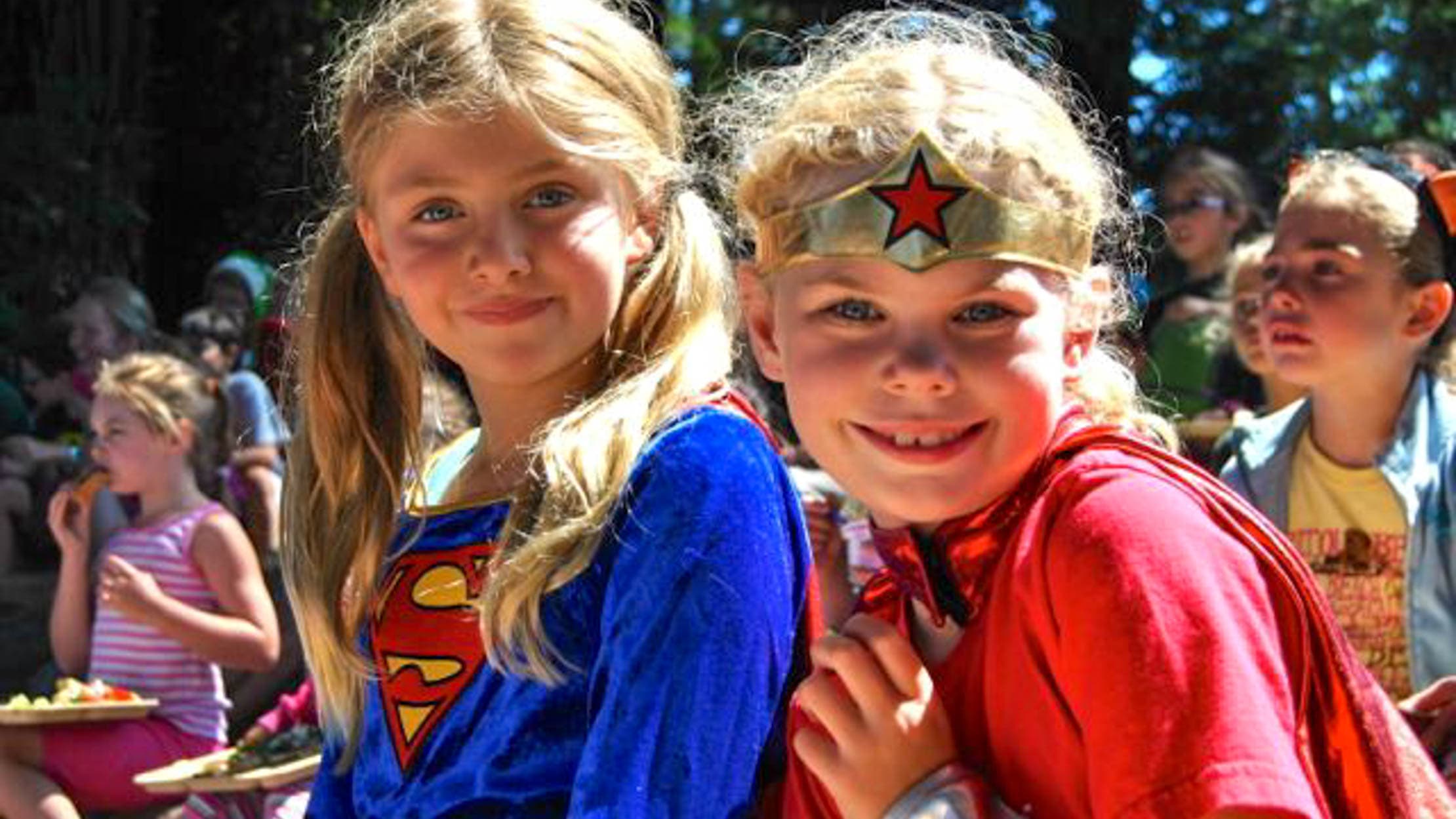 Girls dressed as Supergirl and Wonder Woman for Friday Funday