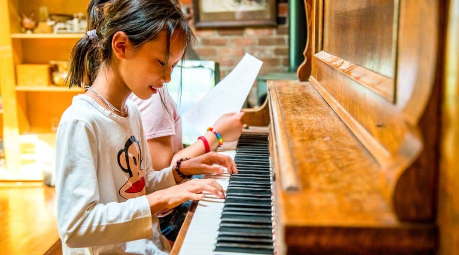 Young girl plays piano at summer camp