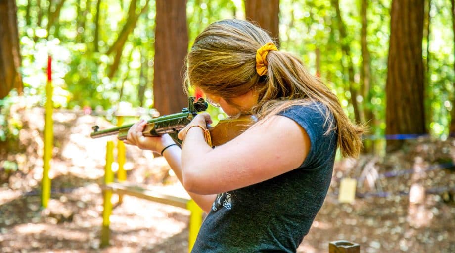 Camper aims rifle at target