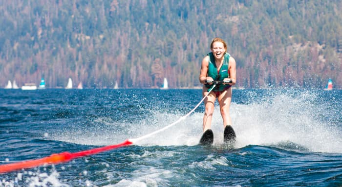 A girl waterskiing and laughing on the lake