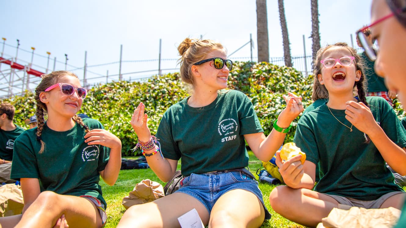 Counselor talks with campers on boardwalk trip