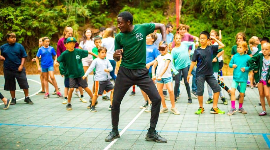 Staff member leads campers in dance