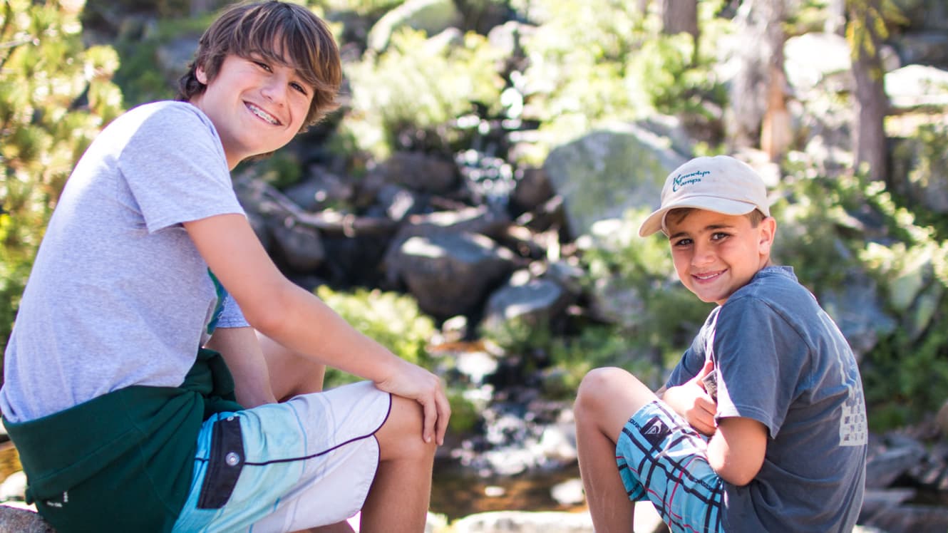 Two campers look backward and smile
