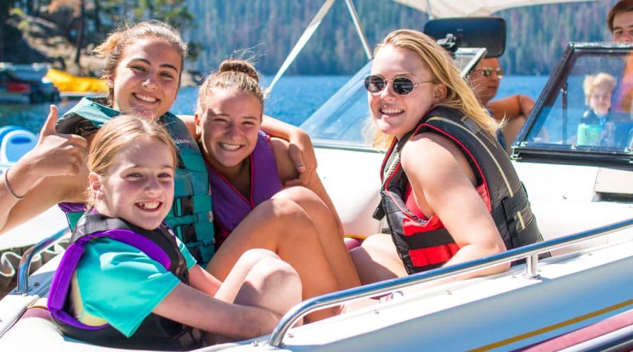 Campers in speed boat smile at camera