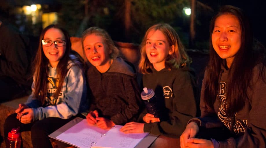 Campers sit in light of campfire