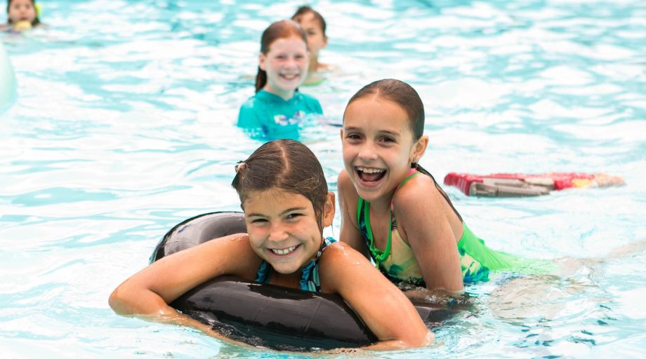 Two campers in the pool with innertubes