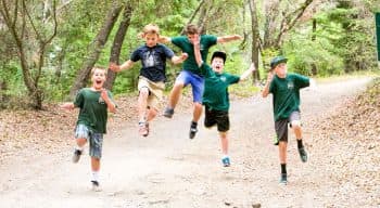 Five boys skipping down a trail