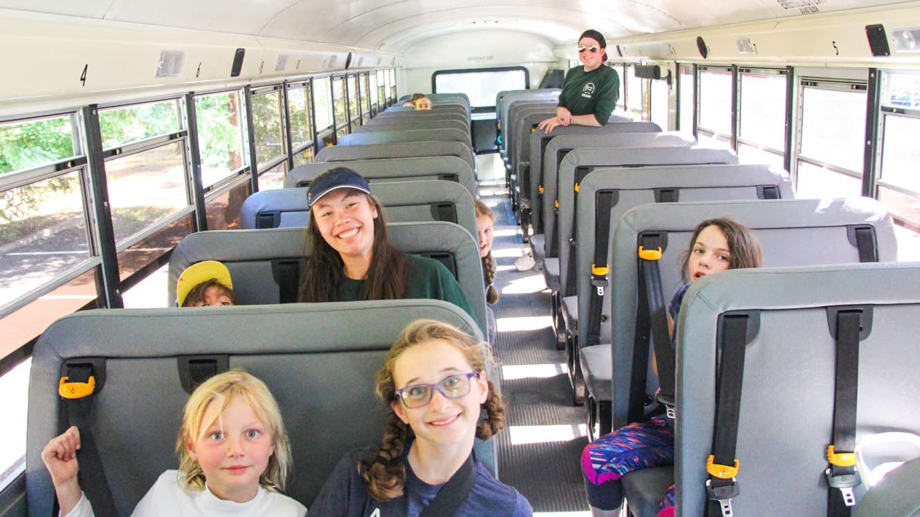 Day campers sit on bus