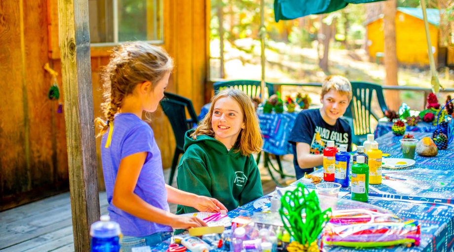 A girl asking a counselor about crafts