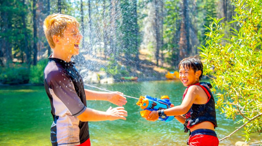 Two boys having a water gun fight