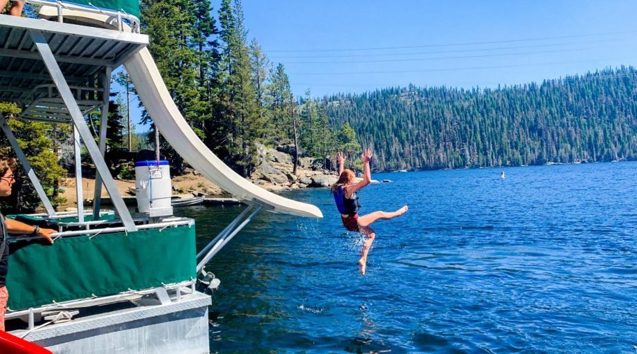 A girl jumping off a slide into water