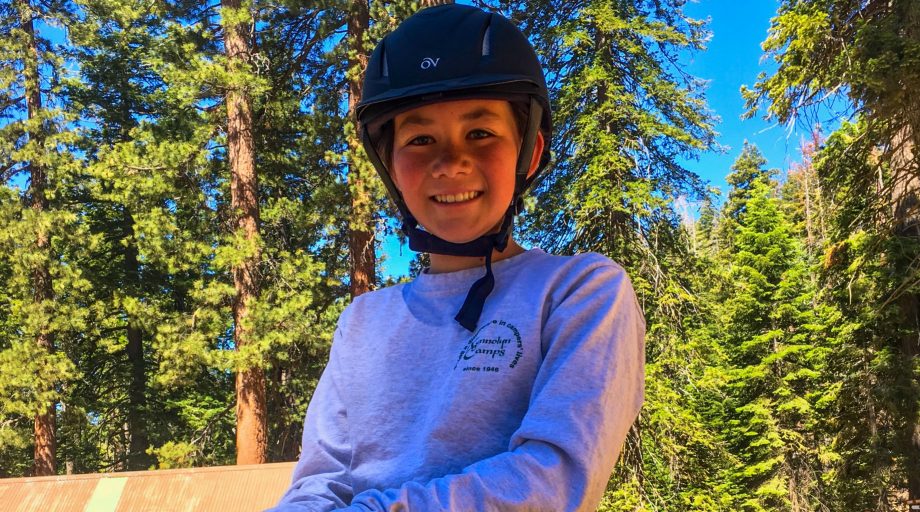 A girl on a horse smilling