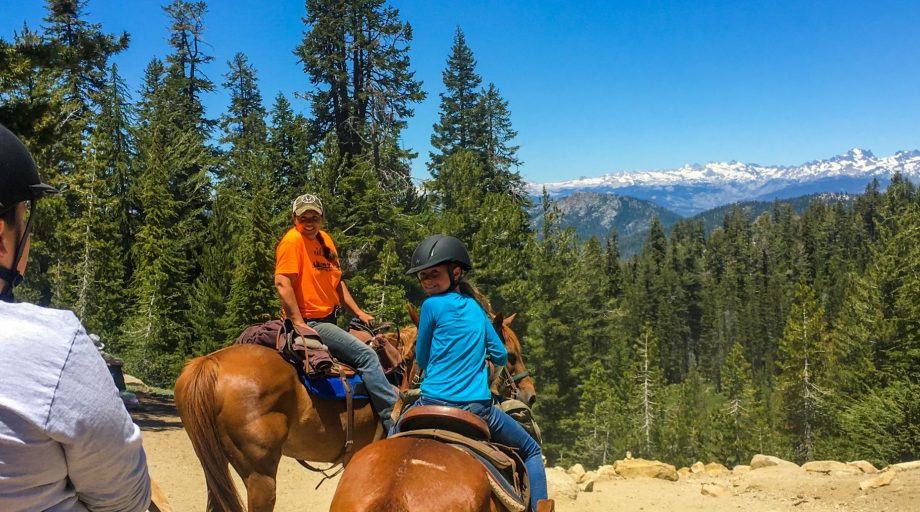 a girl riding a horse on a trail