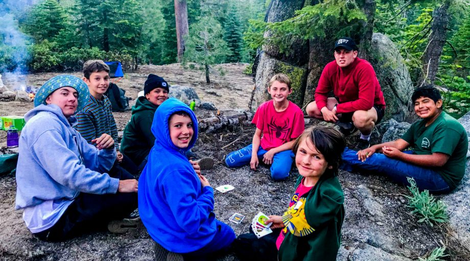 campers around a campfire in the woods