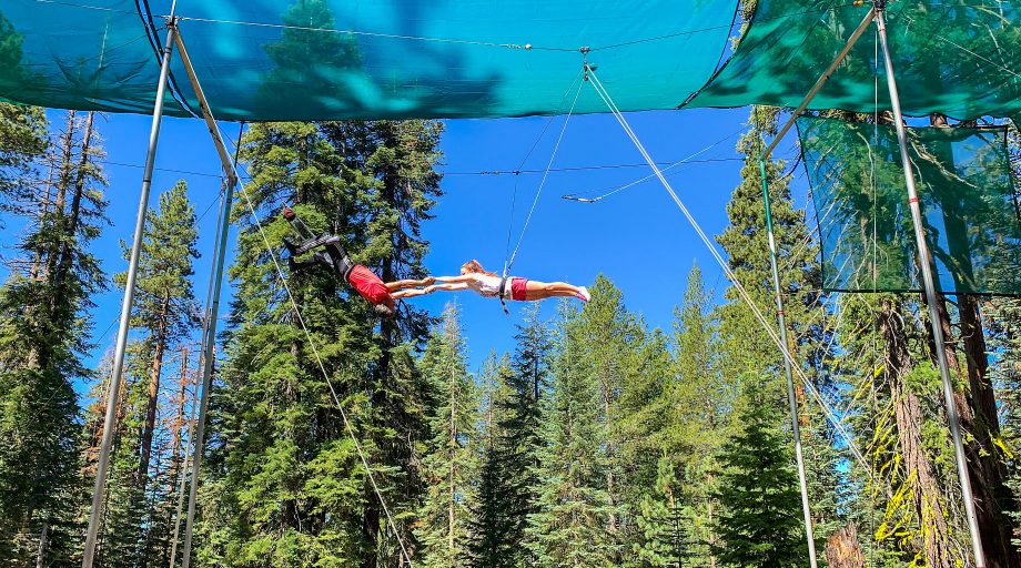 Two kids performing a trapeze stunt